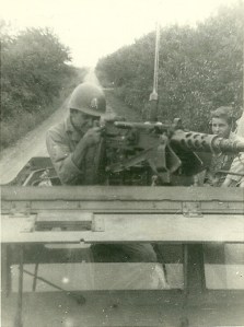 HB Stevens Jr behind 50 cal. anti-tank gun. Radio areal and equipment behind him. Sgt Coulter on seat
